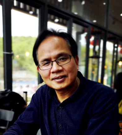 A person wearing glasses and smilingAI-generated content may be incorrect.